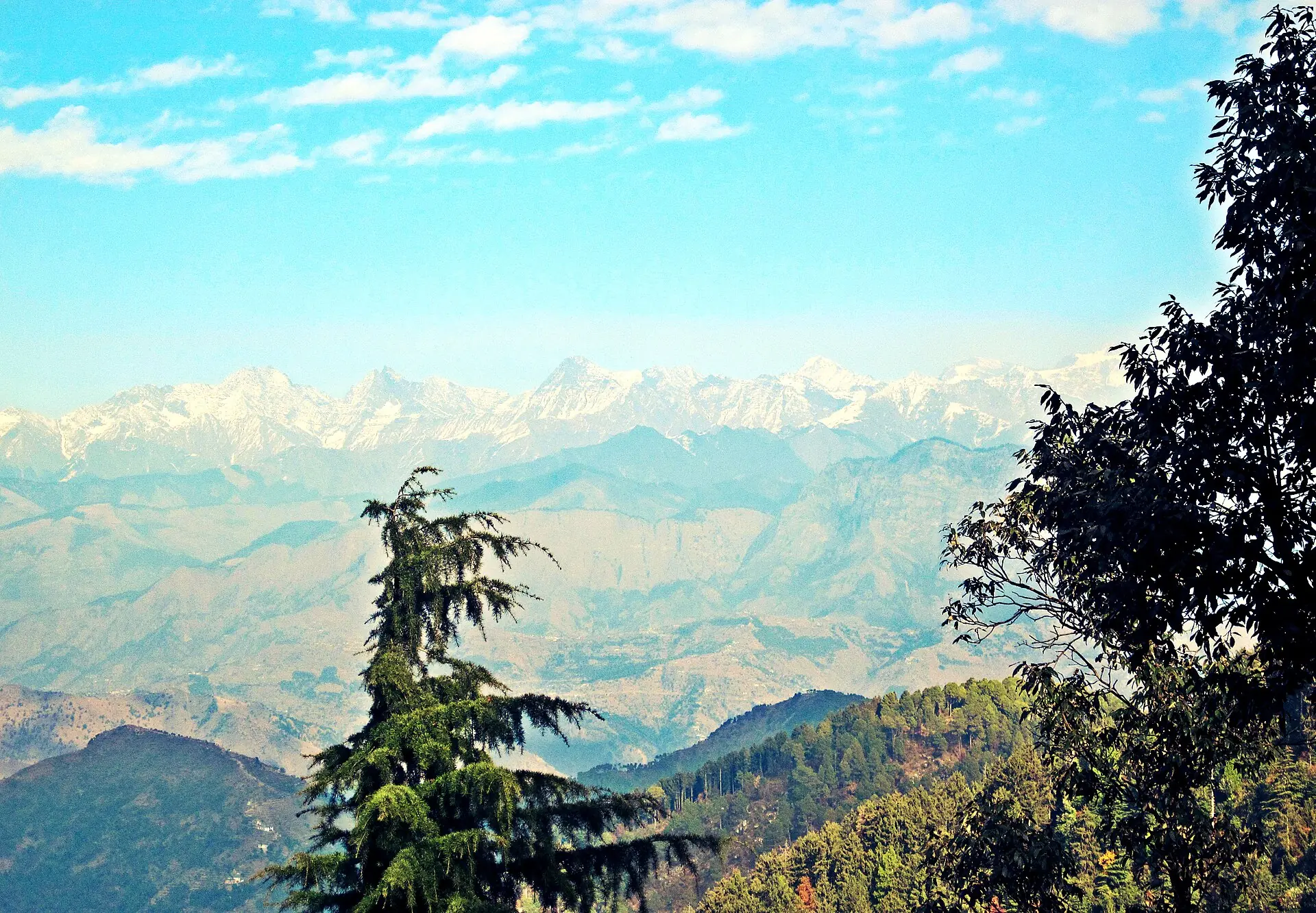 Layered blue mountain ridges and distant snow peaks seen from Dalhousie